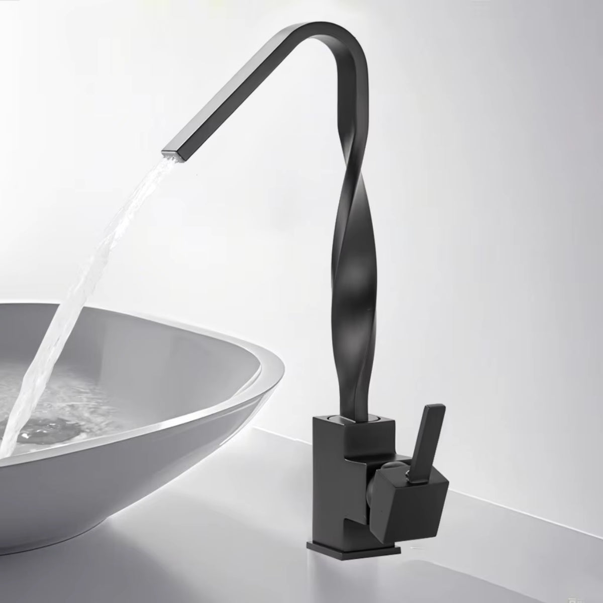 Mitigeur de lavabo ELVAN noir en fonctionnement au-dessus d'une vasque blanche
