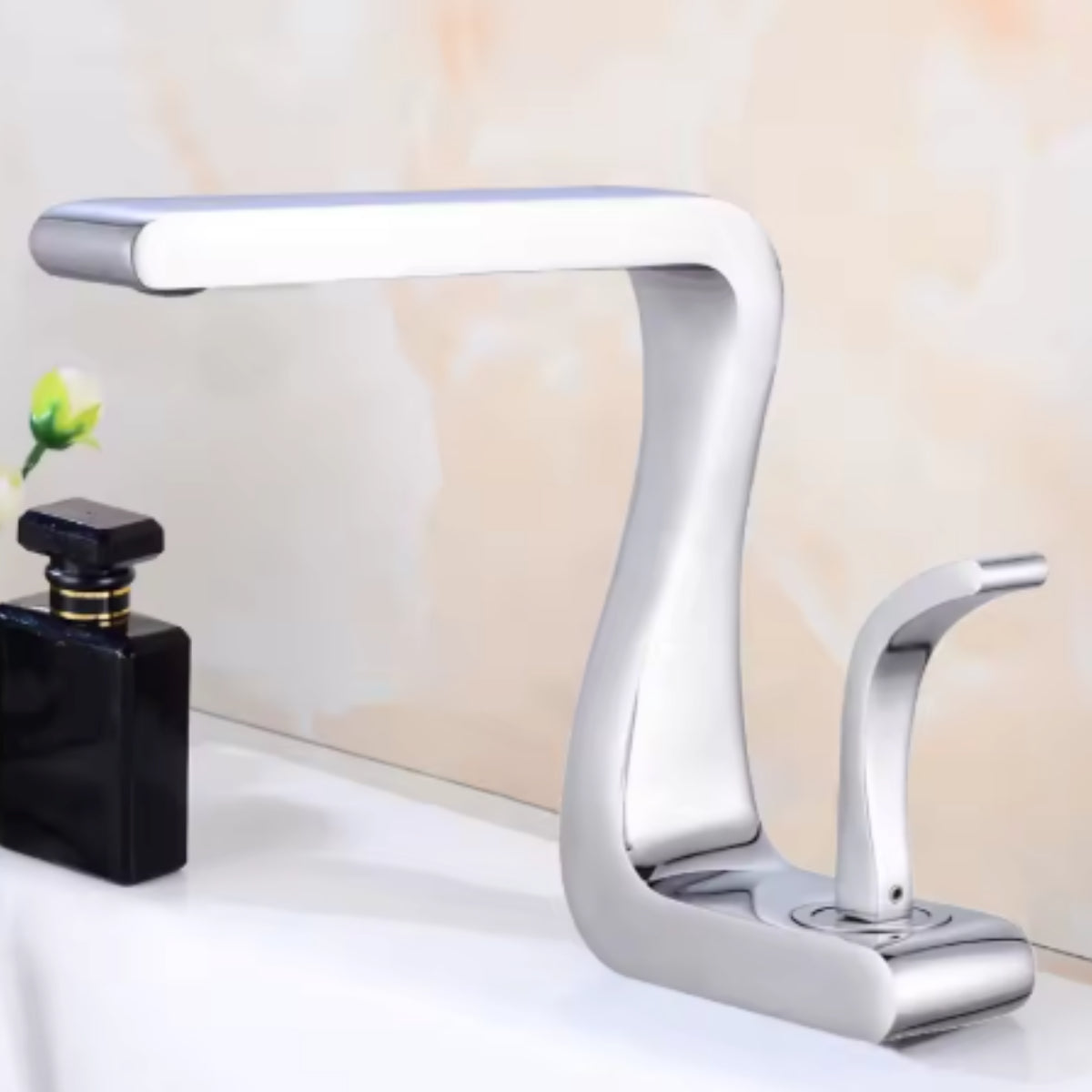 Mitigeur de lavabo MYRAN argent sur un plan de toilette blanc