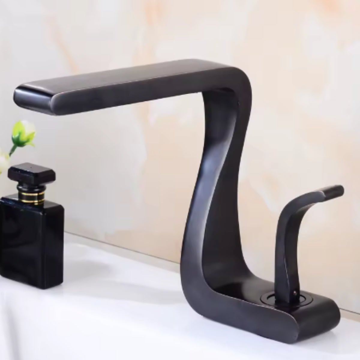 Mitigeur de lavabo MYRAN noir sur un plan de toilette blanc