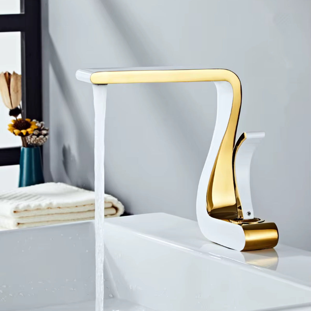 Mitigeur de lavabo MYRAN or et blanc au-dessus d'une vasque blanche