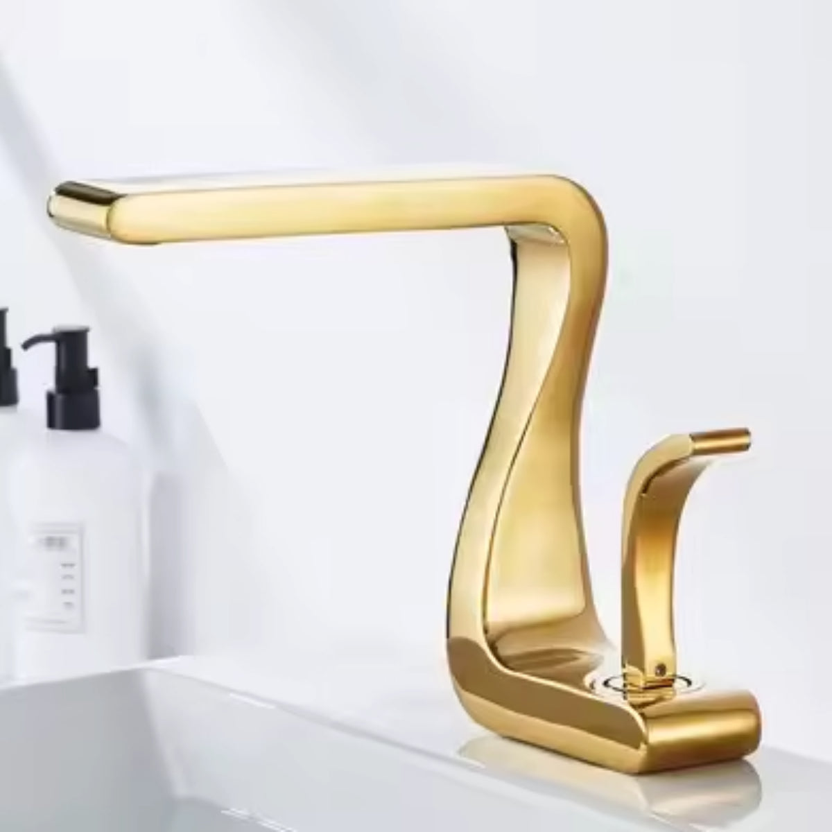 Mitigeur de lavabo MYRAN doré sur un plan de toilette blanc