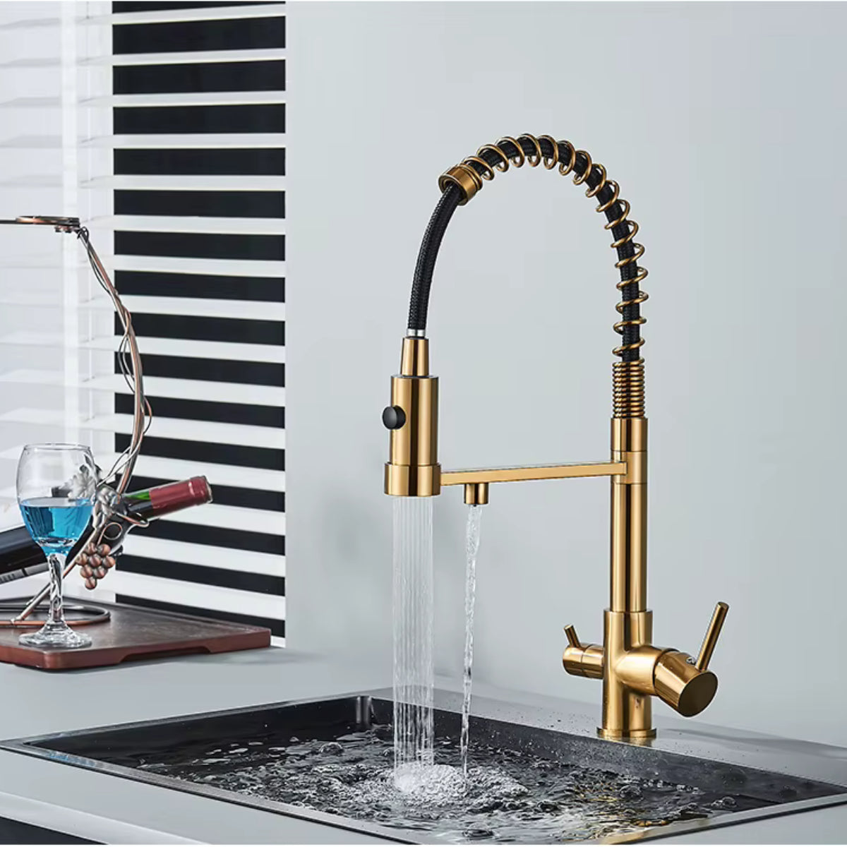 Robinet de cuisine KORVEN doré remplissant un verre au-dessus de l'évier