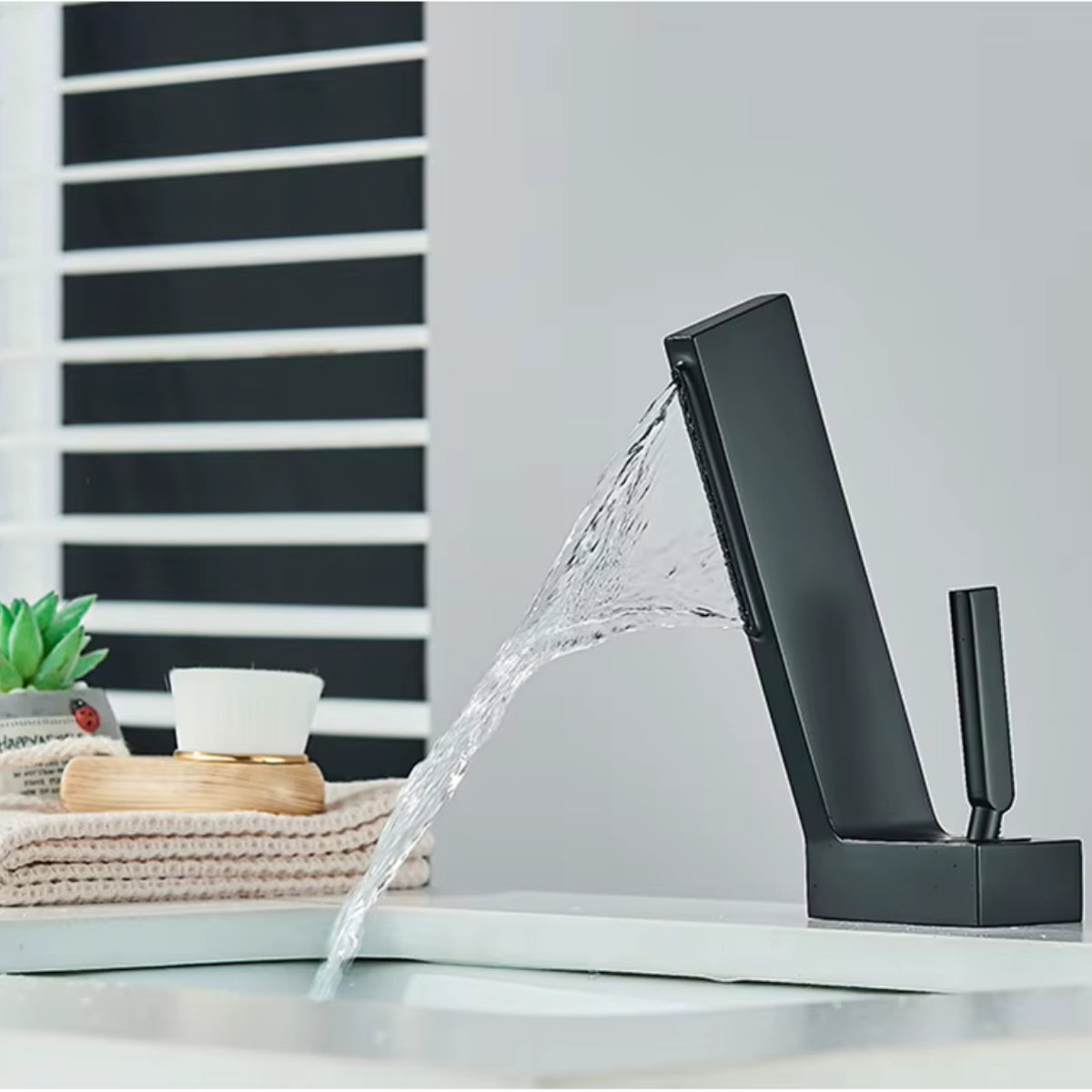 Robinet de lavabo DRAVEN noir en fonctionnement, écoulement en cascade