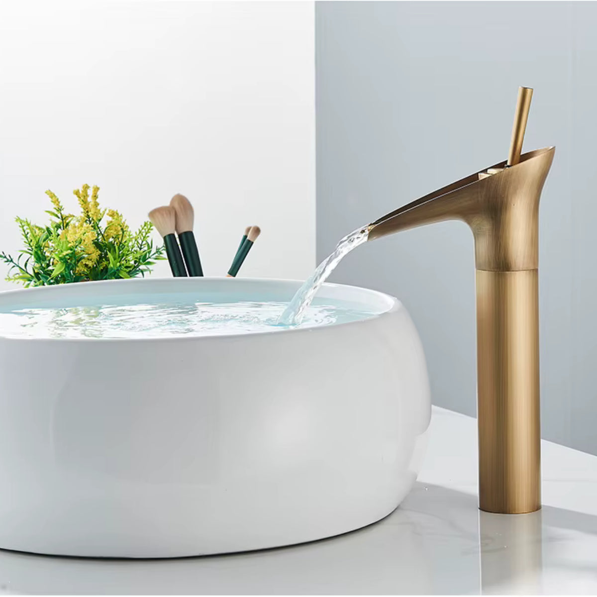 Robinet de lavabo INGRA en laiton vieilli en fonctionnement au-dessus d'une vasque ronde