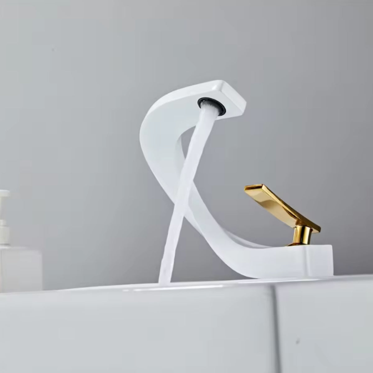 Robinet de lavabo LYRAN blanc et doré au-dessus d'une vasque blanche