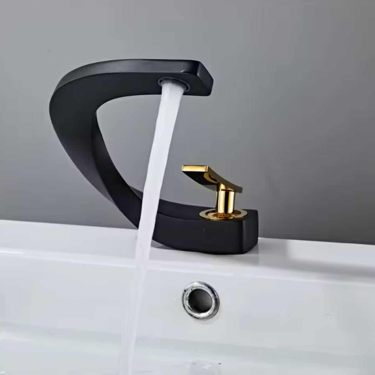 Robinet de lavabo LYRAN noir et doré en fonctionnement, jet d'eau