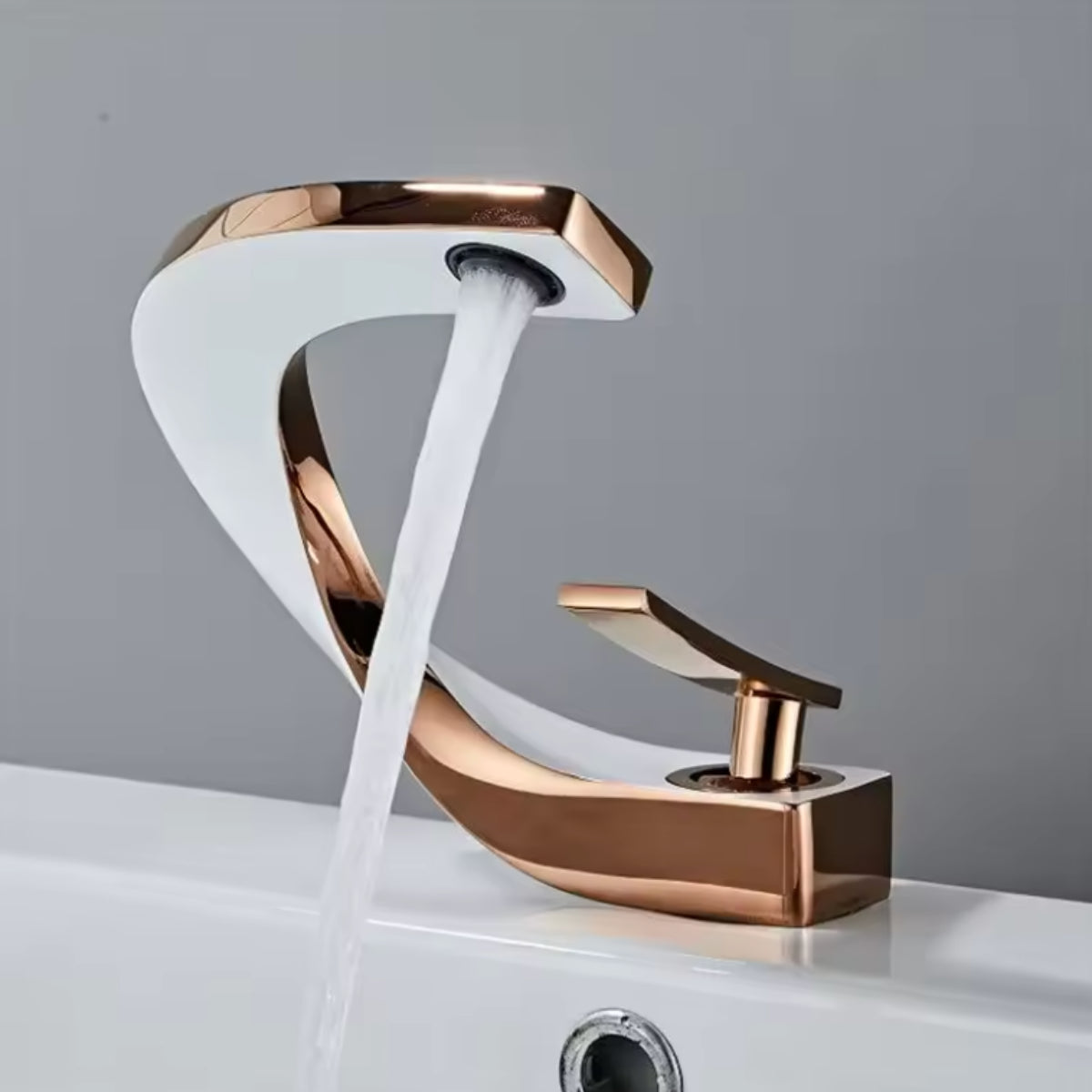 Robinet de lavabo LYRAN or rose et blanc en fonctionnement, jet d'eau