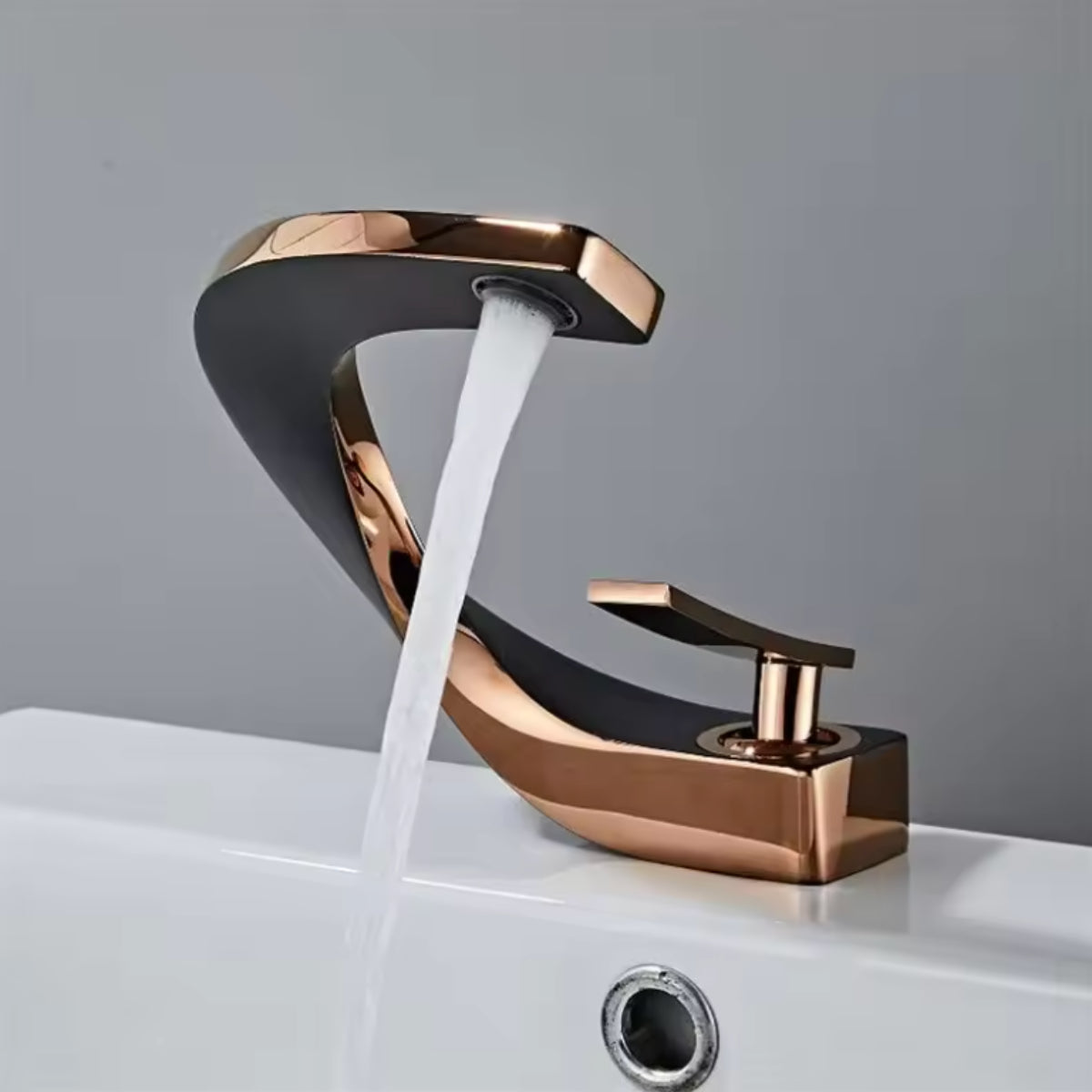 Robinet de lavabo LYRAN or rose et noir en fonctionnement, jet d'eau