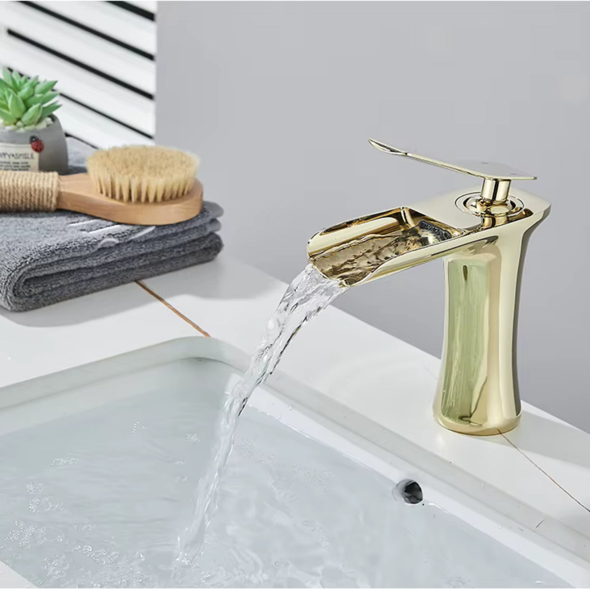 Robinet de lavabo MALEN doré en fonctionnement, écoulement en cascade
