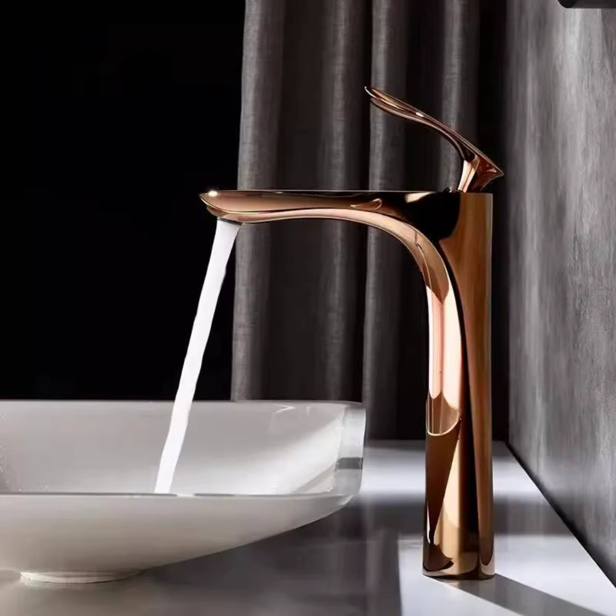 Robinet de lavabo OSVIK or rose en fonctionnement au-dessus d'une vasque blanche