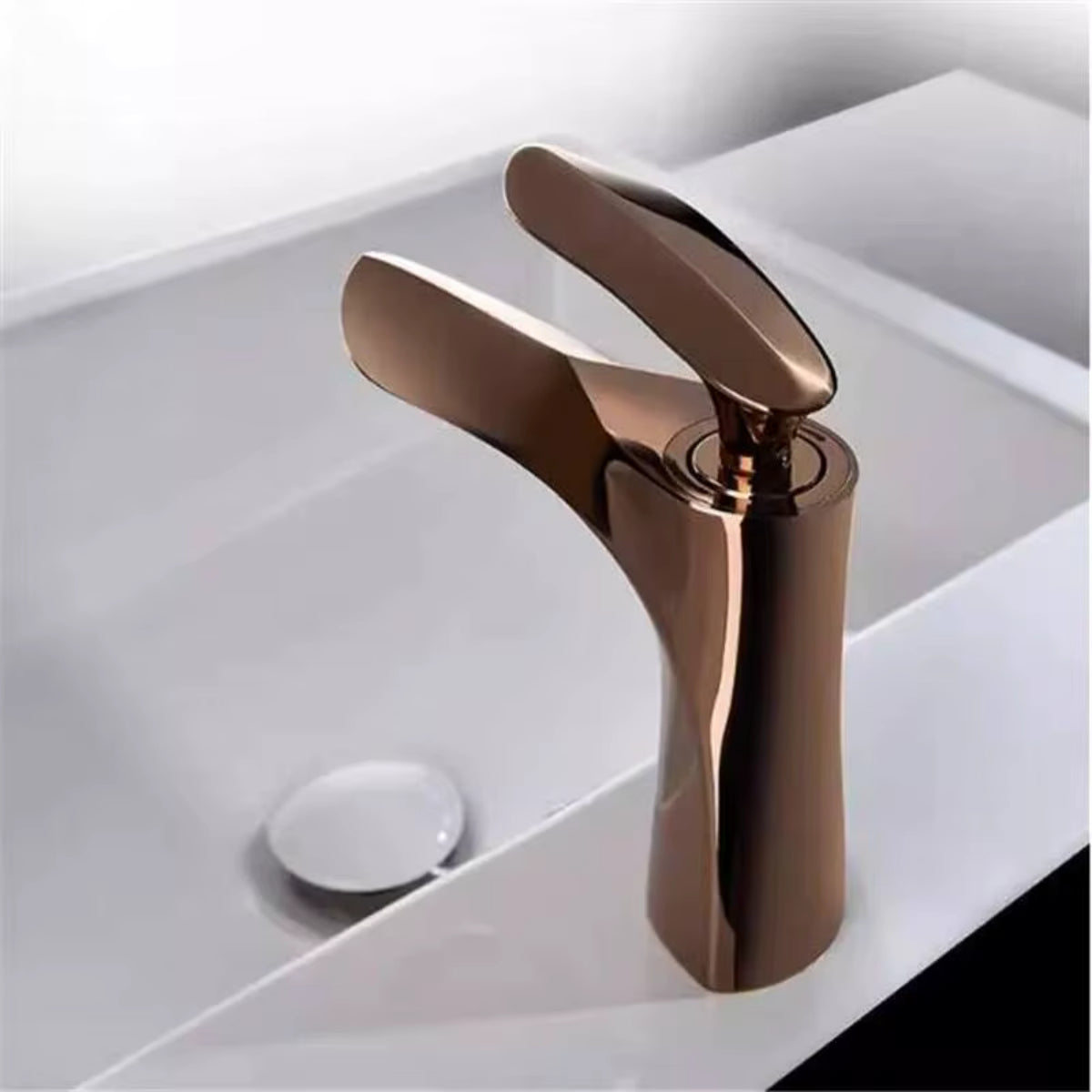 Robinet de lavabo OSVIK or rose vu de profil sur un plan de toilette blanc