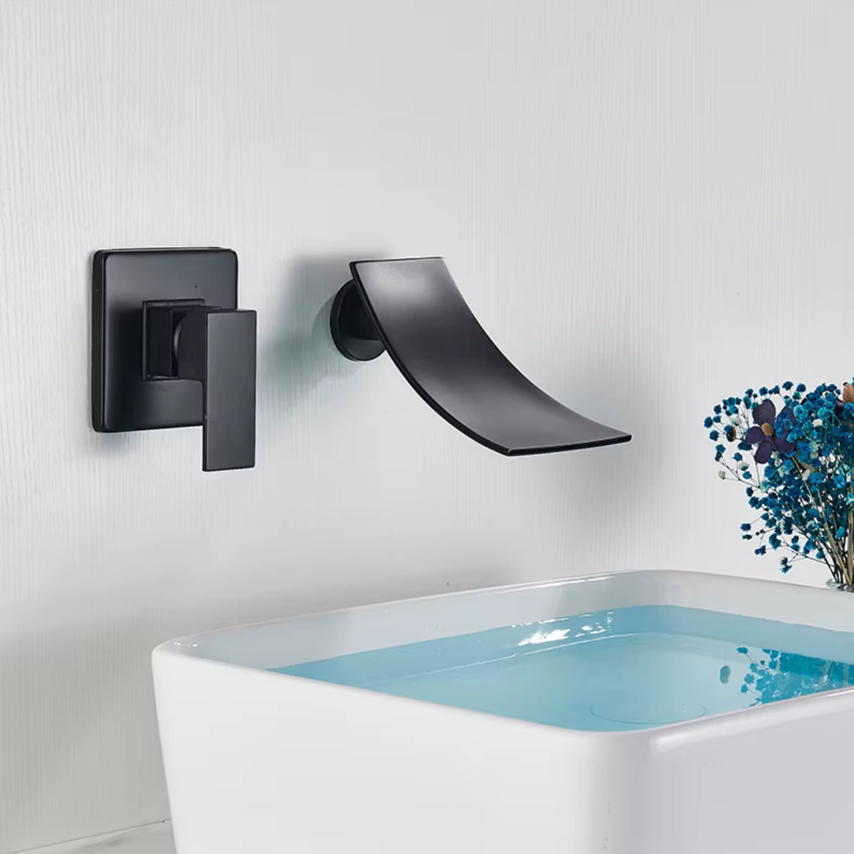 Robinet de lavabo mural RUNAV noir en fonctionnement au-dessus d'une vasque blanche