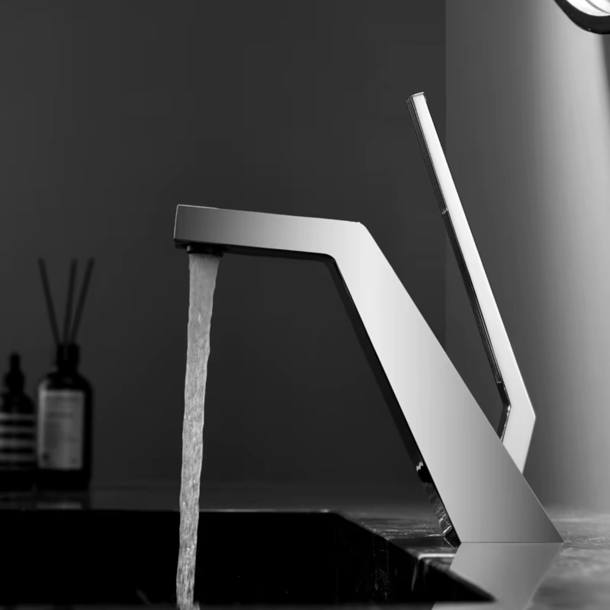 Robinet de lavabo VESTA chromé en fonctionnement sur une vasque sombre